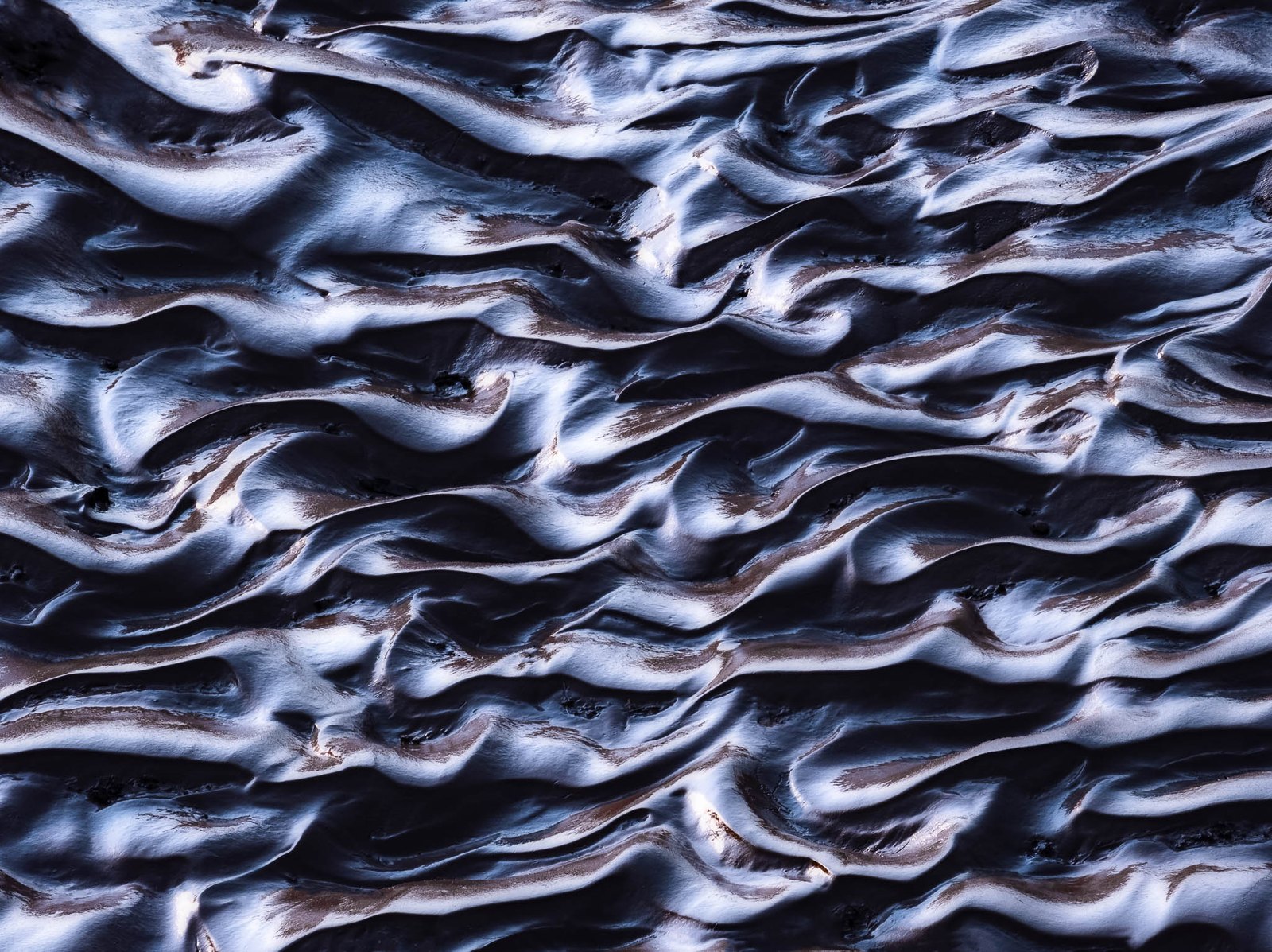 Intimate abstract of silvery rippled patterns in desert mud and sand, by David Kingham
