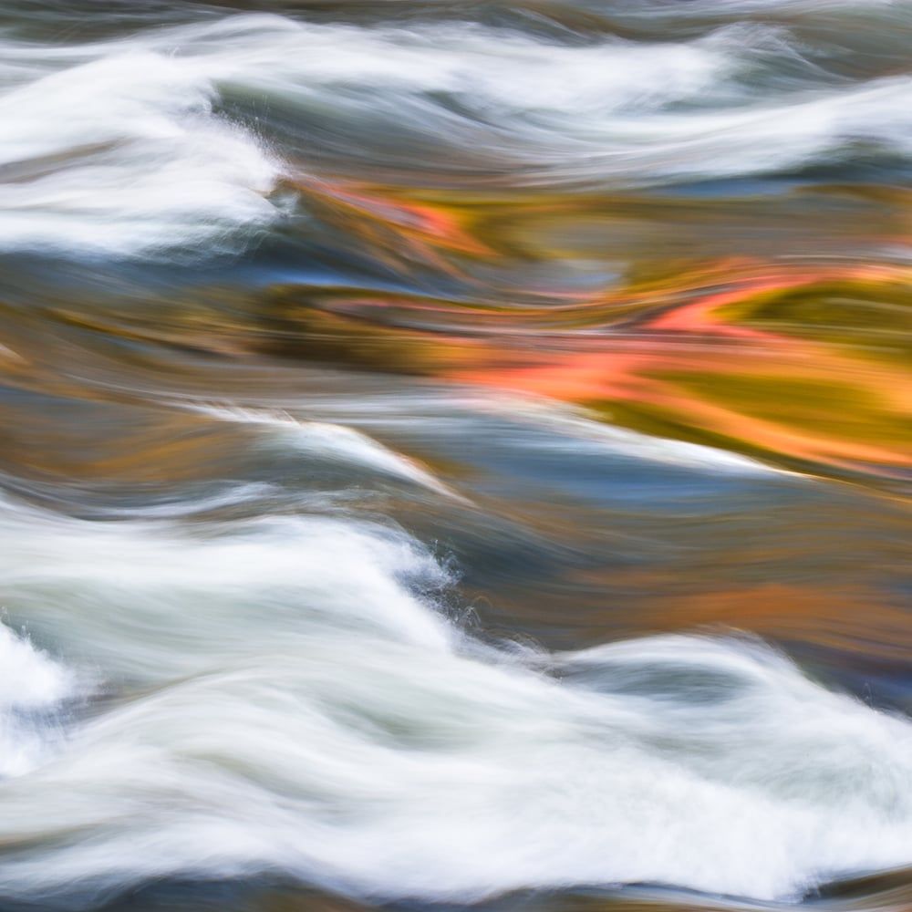 Autumn colors reflected in the white-water swirls of a flowing river, an intimate abstract, by Michael Frye